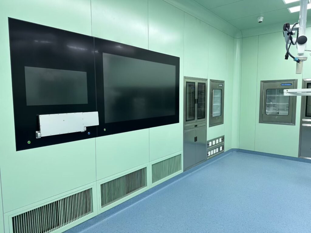 Interior of a modern hospital operating room constructed with OSIDEK modular antibacterial wall panels, integrated return air grilles, and flush-mounted architectural housings.