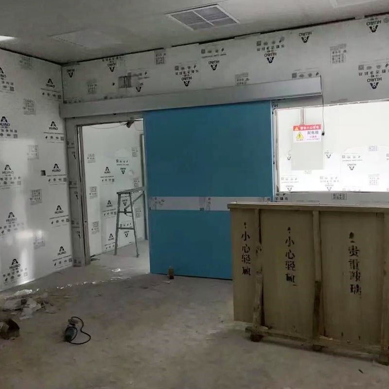 On-site installation of a customized 3.0mm Pb motorized lead-lined sliding door for a hospital DR suite retrofitting project by OSIDEK.